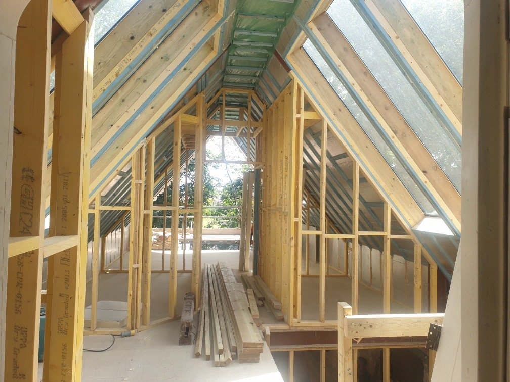New timber stud walls and roof framing inside the building, with glazing set into the roof slopes
